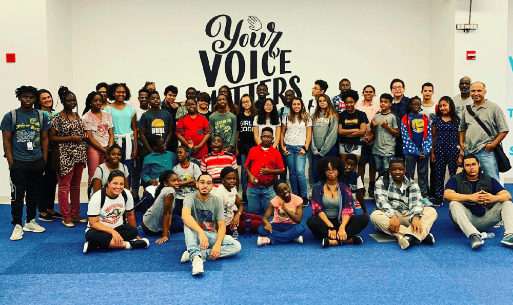 Bruce Street School for the Deaf students posting at VOICE 2019 in front of a sign that reads 