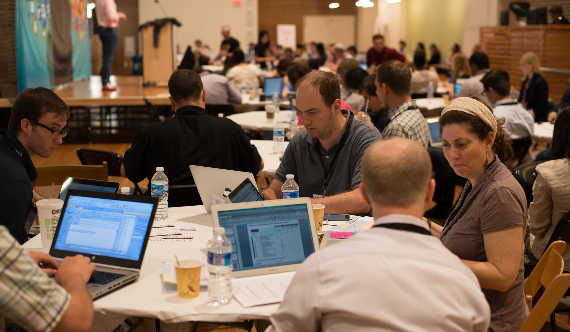 People seated at a conference workshop with laptops